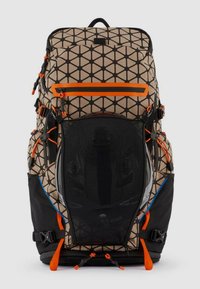 Zaino con motivo geometrico beige e nero, dettagli arancioni, maniglia superiore, spallacci regolabili e scomparto in rete frontale.
