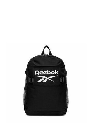 Czarny plecak Reebok z dużym białym logo, przednią kieszenią na zamek, regulowanymi bocznymi paskami oraz siateczkowymi kieszeniami bocznymi, pokazany na białym tle.