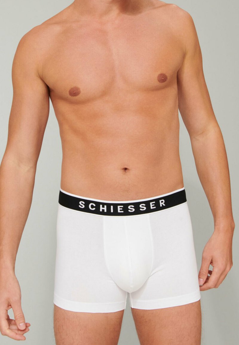 White cotton boxer briefs with a black waistband featuring the brand name "SCHIESSER" in white text. Soft, fitted design with moderate coverage.