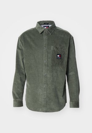 Grünes Cordhemd mit langen Ärmeln, Knopfleiste vorne, Brusttasche mit kleinem rechteckigem Logo-Patch.