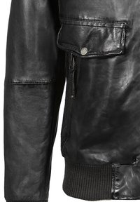 Černý kožený rukáv bundy a kapsa se zapínáním na cvok a zip, s detaily žebrovaného pleteného lemu na manžetě a spodním okraji.