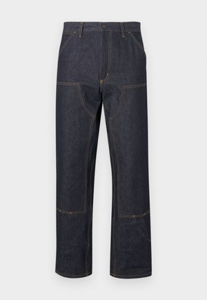 Dark denim trousers with a relaxed fit, featuring yellow stitching, front pockets, and a distinctive seam design.