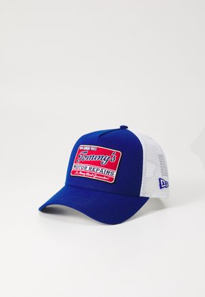 Blauer Hut mit einem weißen Netzrücken, der ein rot-weiß gesticktes Patch trägt, auf dem "Tommy's Motor Repairs" steht. Mit gebogenem Schirm.