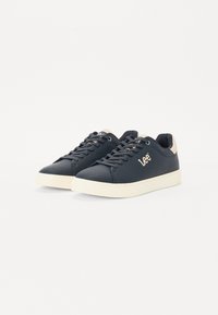 Baskets bleu marine avec une tige synthétique lisse, accents beige clair sur le talon et une semelle en caoutchouc blanc, dotées de lacets ton sur ton.