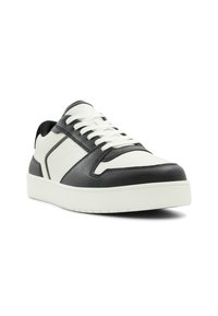Black and white sneakers with textured leather upper, lace closure, padded collar, and a chunky white rubber sole.