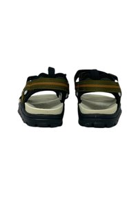 Sandalo nero e verde con fasce spesse, chiusure regolabili e una soletta bianca imbottita con suola nera testurizzata.