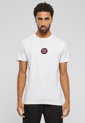 Hvid bomulds t-shirt med en rund lap med sort og rød tekst "BALLIN 23" på brystet. Korte ærmer og rund halsudskæring.
