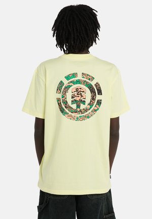 Jasnożółta koszulka z krótkim rękawem, z okrągłym nadrukiem na plecach w odcieniach ziemi i abstrakcyjnych wzorach. Miękka bawełniana tkanina.