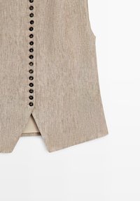 Beige mouwloos vest met een rij kleine zwarte knopen in het midden en een voorzie split aan de zoom.