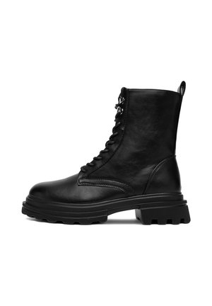 Botines negros de cuero con cierre de cordones en la parte delantera, suela gruesa de goma, acabado texturizado y detalles sutiles de costura.