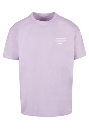 Lilac cotton t-shirt with a relaxed fit, crew neck, short sleeves, and white printed text on the front. Soft texture, minimal design.