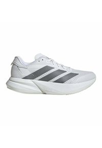 Zapatilla atlética blanca con detalles en gris y diseño de tres rayas. Presenta un upper texturizado, cierre con cordones y suela acolchada.