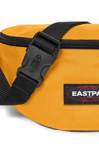 Banane Eastpak jaune avec fermeture éclair noire, sangle noire réglable et boucle en plastique.