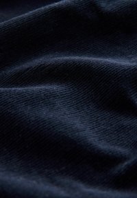 Tăietură de catifea bleumarin, cu o textură ribbed vizibilă, având o cădere moale și netedă și un luciu subtil. Fără modele sau detalii suplimentare.