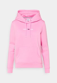 Vaaleanpunainen huppari pehmeästä kankaasta. Siinä on etutasku, säädettävä huppu nauhoilla ja painettu "TOMMY JEANS" -logo tuotemerkin väreissä.