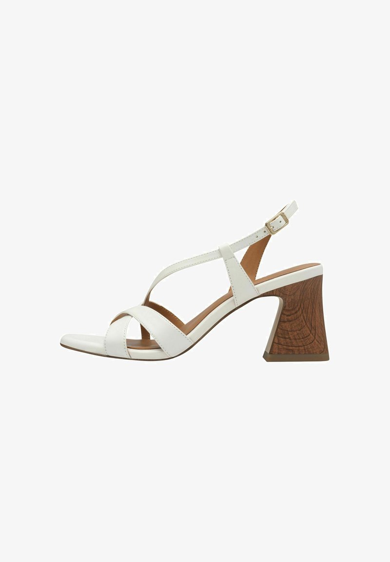 White leather sandal with crisscross straps, open toe, and a brown, textured block heel. Adjustable ankle strap with gold buckle detail.