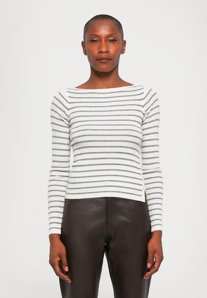 Tunique rayée à manches longues en blanc et bleu marine, texture tricot côtelée, encolure bateau, silhouette ajustée, associée à un pantalon en cuir marron.