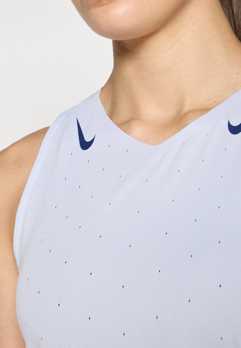 Lichtblauw mouwloos sporttop met een v-hals, met donkerblauwe Nike-logo's en kleine perforaties voor ademend vermogen.
