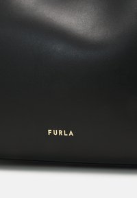 Fekete bőr kézitáska sima textúrával, arany "FURLA" logóval. Egyszerű dizájn, jól meghatározott sziluettel.