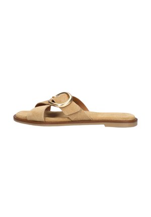 Beige suède platte slidessandaal met een brede band die over de voet loopt en een grote ronde gouden gesp bovenop.