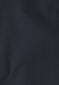 Tissu en maille bleu marine foncé avec une texture fine, présentant un motif régulier et une surface lisse, adapté à diverses utilisations vestimentaires.