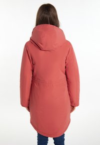 Pardessus imbottito in corallo, con cappuccio e vita arricciata, caratterizzato da una texture liscia e una parte posteriore più lunga. Cuciture rinforzate visibili.