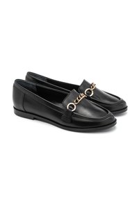 Black leather loafers with a rounded toe, featuring a gold chain accent across the vamp and a flat sole. Smooth, sleek texture.