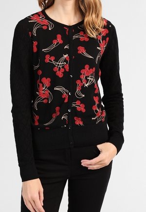 Zwarte cardigan met rood bloemenpatroon, gestructureerde zwarte mouwen, ronde hals en knoopsluiting aan de voorkant. Ribgebreide zoom en manchetten maken het ontwerp compleet.