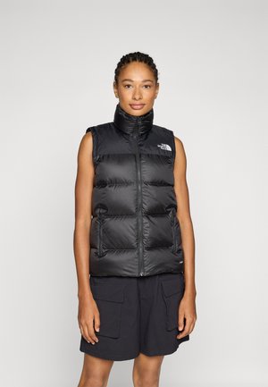 Zwarte puffer vest met hoge hals, ritsluiting en zijzakken. Bevat gestikte secties en een logo aan de bovenkant aan de linkerkant.