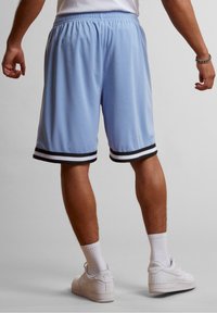 Shorts de sport bleu clair avec un ourlet rayé noir et blanc, dotés d'une taille élastique et d'un tissu lisse et respirant.