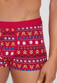 Boxers rojos con estampado de renos, Papá Noel, galletas de jengibre y árboles de Navidad, con tela suave y elástica y una cintura roja.