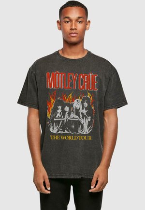 Black cotton t-shirt featuring a graphic print of a rock band, with red flames and yellow text reading "THE WORLD TOUR." Relaxed fit design.