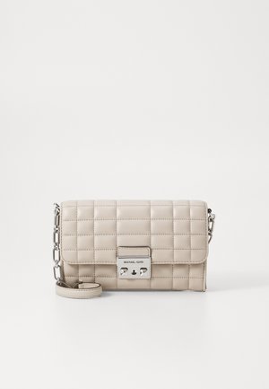 Sac en bandoulière en cuir matelassé beige avec quincaillerie en argent et chaîne. Comprend un rabat avant et une plaque de logo sur le fermoir.