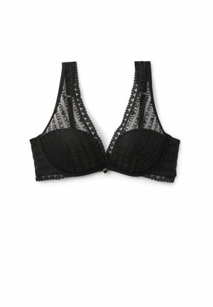 Soutien-gorge en dentelle noire avec des bonnets transparents, des bords festonnés et un charme central. Il présente un motif géométrique, des bretelles ajustables et un soutien avec armatures.