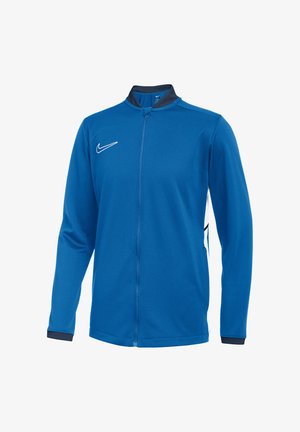 Blå sportsjakke med fuld lynlås, lange ærmer, sort krave og manchetter, hvid Nike swoosh-logo på brystet og hvide sidepaneler.