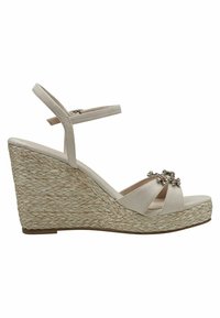 Μπεζ σουέτ φλατφόρμα με λουράκι αστραγάλου, πλατφόρμα από πλεγμένο σχοινί και διακοσμητικά ασημένια λουλούδια στις μπροστινές λωρίδες.