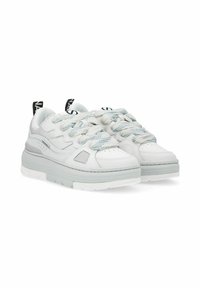 Sneaker bianca con suola a strati e pannelli testurizzati, dotata di lacci rotondi blu e grigi, e linguetta posteriore con logo.