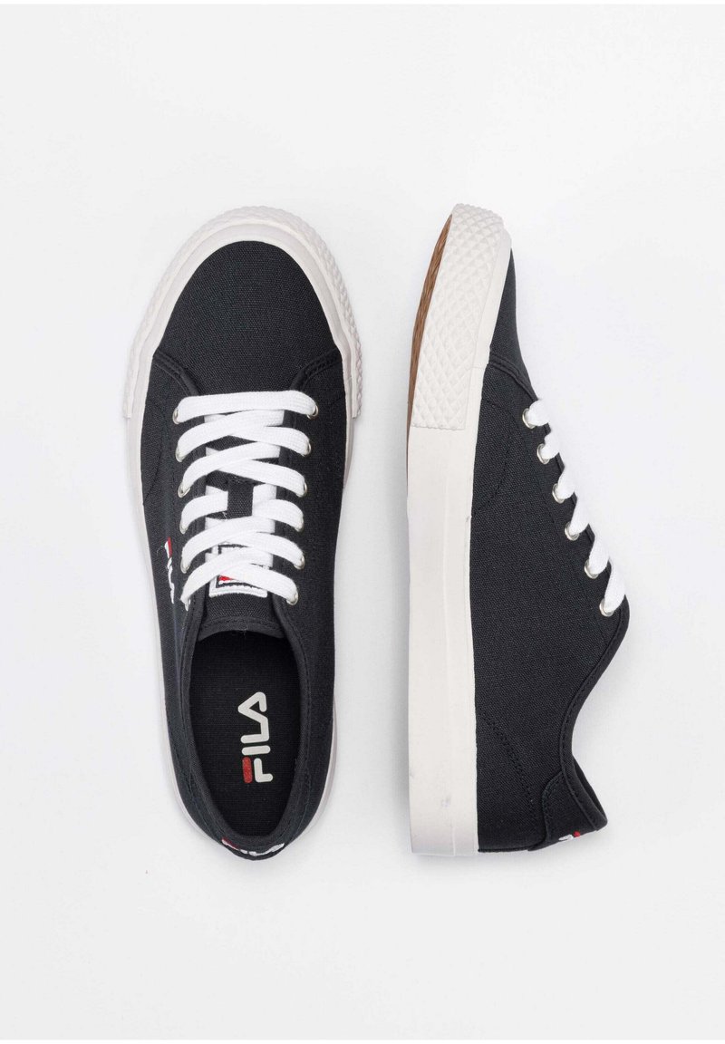 Zapatillas de lona negras con cordones blancos, suelas de goma y acentos texturizados. Logo de Fila visible en la lengüeta, diseño y forma clásica.