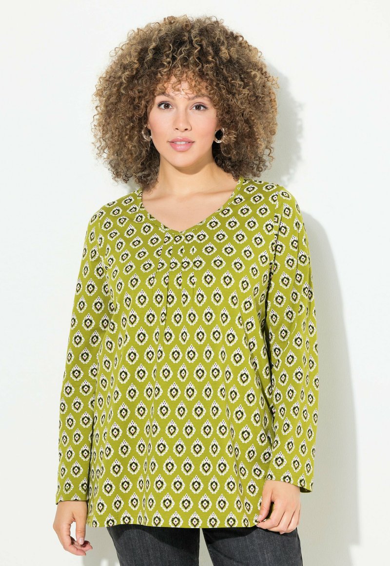 Grüne Bluse mit Muster, V-Ausschnitt, langen Ärmeln und geometrischen Designs in Weiß und Schwarz, aus leichtem Stoff gefertigt.
