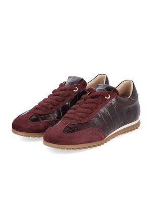Een paar donkerbordeauxrode lage sneakers van suède en gestructureerd leer, dikke bijpassende veters en lichtbruine rubberen zolen.
