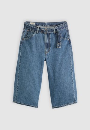 Denim-shortsit keskisinisessä värissä, korkealla vyötäröllä, varustettu vyötärölenkillä, suurilla etutaskuilla ja löysällä mallilla, jossa on huolitellut reunat.