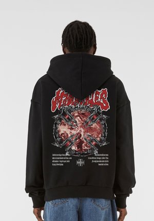 Czarna bluza z kapturem z dużym czerwono-białym nadrukiem na plecach. Projekt zawiera skomplikowane grafiki z czaszkami i elementami tekstowymi.