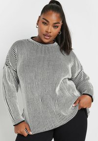 Maglione oversize a righe bianche e nere con scollo rotondo e polsini a costine, caratterizzato da una texture morbida e una vestibilità rilassata.