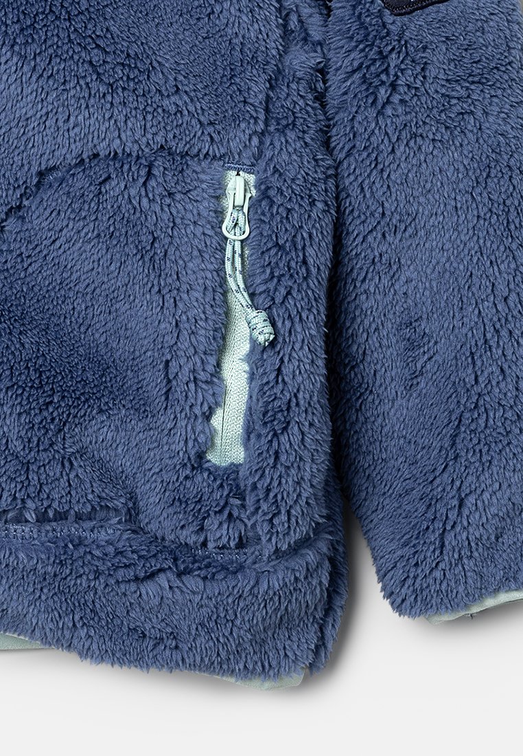 Fleece-Jacke in Dunkelblau mit einer weichen, strukturierten Oberfläche. Verfügt über eine hellblaue Reißverschlusstasche und passende Reißverschlussdetails.
