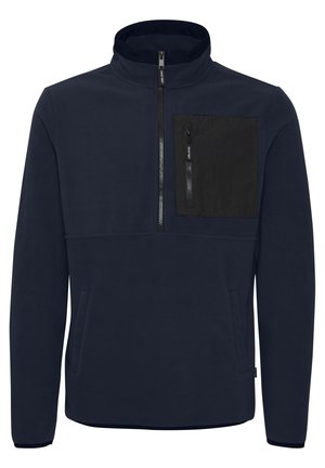 Pulover din fleece de culoare bleumarin cu un guler înalt, fermoar la jumătate în față și o mică buzunar negru pe piept. Are o textură moale și două buzunare laterale.