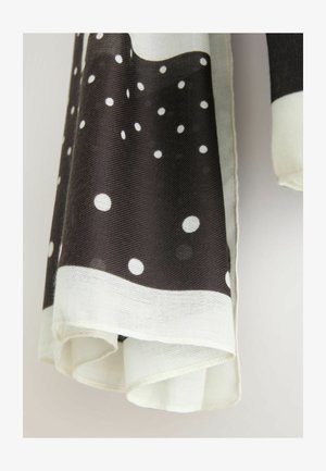 Črno-bijeli šal s uzorkom velikih bijelih točkica na tamnoj pozadini, s kontrastnim bijelim rubom i mekanom, teksturiranom tkaninom.