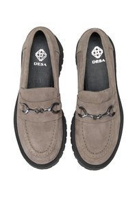 Graue Wildleder-Loafers mit einer schwarzen Gummisohle, ausgestattet mit einem dekorativen metallischen Kettenakzent und kontrastierenden Nähdetails.