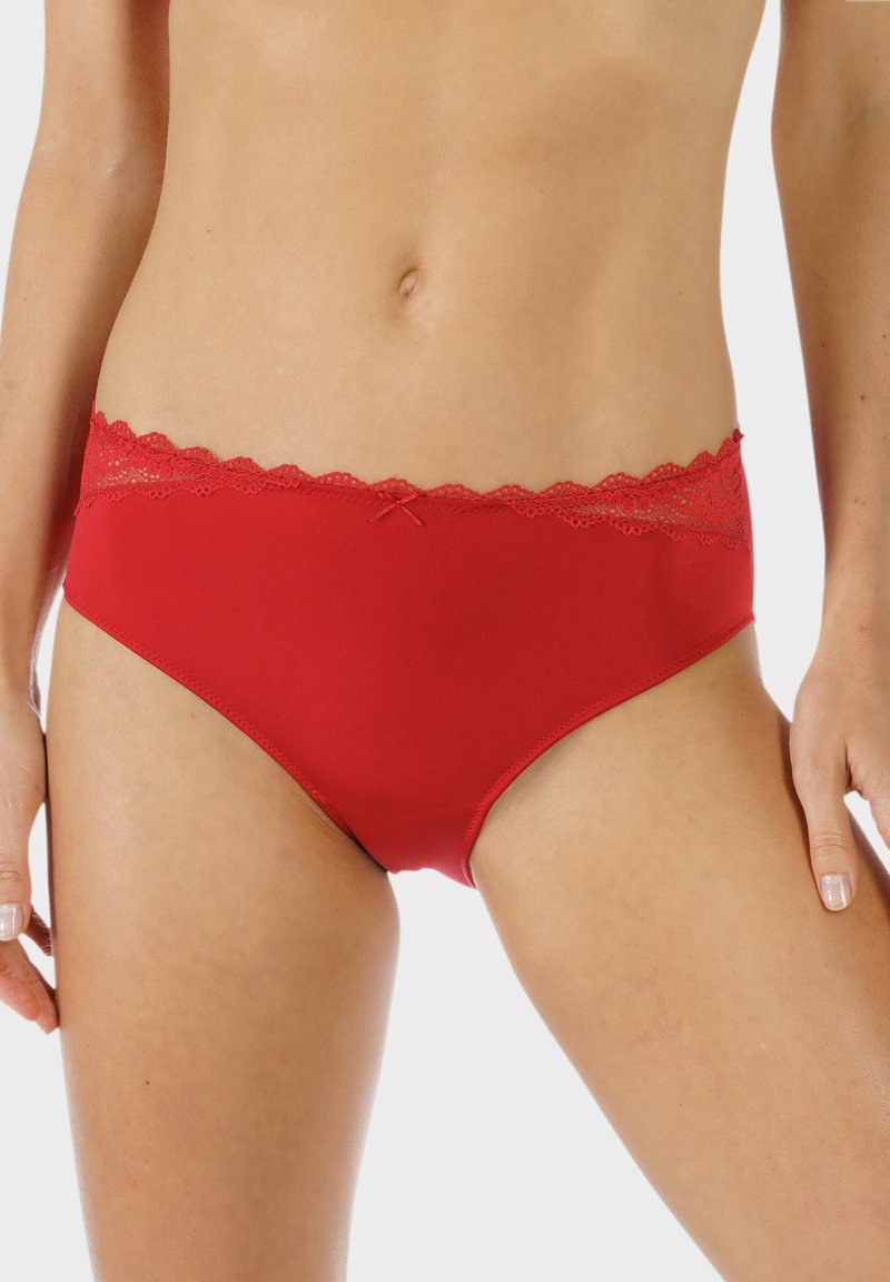 Mutande rosse a slip con una superficie liscia, rifinite con pizzo lungo l'elastico in vita, accentuate da un piccolo fiocco al centro.