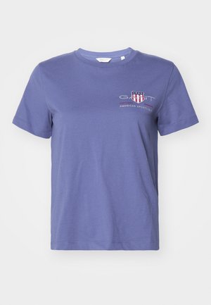 Camiseta de algodón morada con mangas cortas, cuello redondo y un gráfico frontal que presenta "GANT" y "AMERICAN SPORTSWEAR" en rojo y blanco.