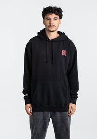 Schwarzer Kapuzenpullover mit Fronttasche, versehen mit rotem "91"-Logo, verstellbaren Kordeln sowie gerippten Bündchen und Saum. Weiches Material, lockere Passform.